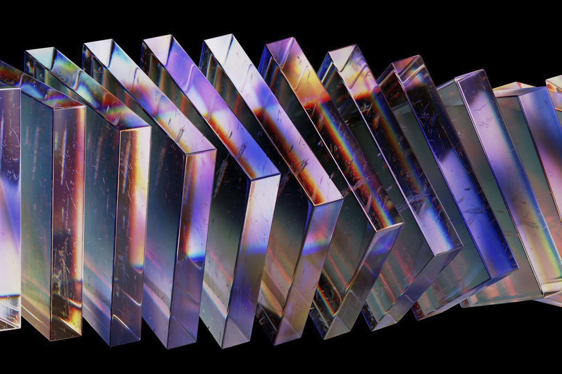 A row of glass panels refracting rainbow light, on a black background.